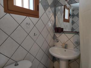 a white bathroom with a sink and a toilet at Maroulios Apartment in Elafonisos +7 photos