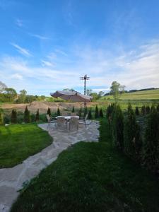 a patio with a table and an umbrella at Chatka M3 in Abrahamovce