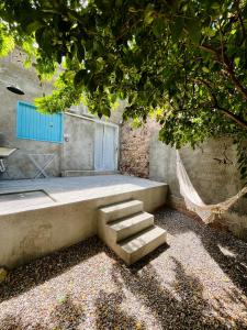 a concrete bench with steps and a hammock under a tree at CASINHA JASMIM, vila florescer, centro histórico!! in Piranhas