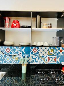 una cucina con piastrelle bianche e blu e piano cottura di CASINHA JASMIM, vila florescer, centro histórico!! a Piranhas