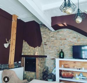 ein Wohnzimmer mit einer Steinmauer und einem Kamin in der Unterkunft Casa Ani in Amposta