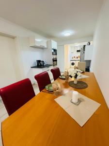 a dining room with a wooden table and red chairs at Ferienwohnung in Aistersheim in Aistersheim