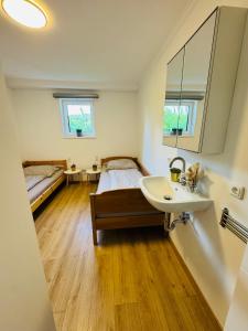 a bathroom with a sink and a bed and a mirror at Ferienwohnung in Aistersheim in Aistersheim