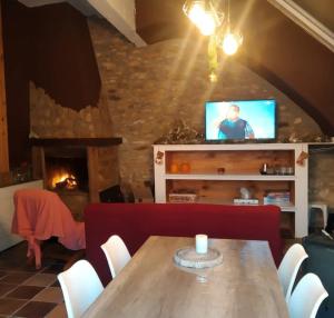 ein Esszimmer mit einem Holztisch und einem TV in der Unterkunft Casa Ani in Amposta