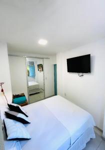 una camera con letto bianco e TV a schermo piatto di CASINHA JASMIM, vila florescer, centro histórico!! a Piranhas Altre 22 foto