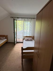 a bedroom with two beds and a sliding glass door at Apartmani Rada in Prolomska Banja