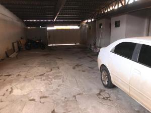 a white car parked inside of a garage at Hotel Preço Popular in Novo Gama