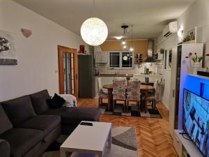 ein Wohnzimmer mit einer Couch und einem Tisch in der Unterkunft Apartment Sanja in Rab