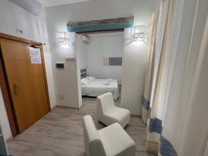 サンタ・テレーザ・ガッルーラにあるHotel Da Ceccoのベッドと椅子付きの小さな部屋です。 +37枚の写真
