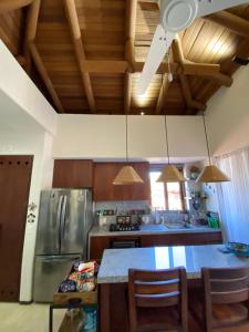 a kitchen with wooden ceilings and a table with chairs at Dario Dolce Sweet Dario Penthouse Suite in Zihuatanejo