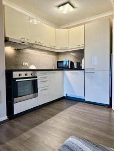 an empty kitchen with white cabinets and appliances at Schniekes Ferienhaus - Urlaub mit Hund im bayerischen Wald in Zandt