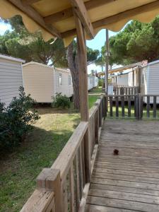 a wooden boardwalk leading to a yard with houses at mobilhome 232 tohapi marvilla in Torreilles