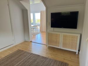 ein Wohnzimmer mit einem Flachbildfernseher an der Wand in der Unterkunft Kustidyll med havsutsikt in Hyppeln