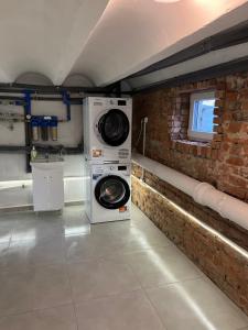a washer and dryer in a room with a brick wall at Niko Stare Miasto z Rowerami in Zamość