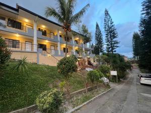 a building with a palm tree next to a street at Infinity pines tagaytay in Sampong