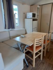 a living room with a table and a couch at mobilhome 232 tohapi marvilla in Torreilles