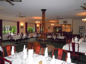 un comedor con mesas y sillas en un restaurante en Tree Top Walk Motel en Walpole