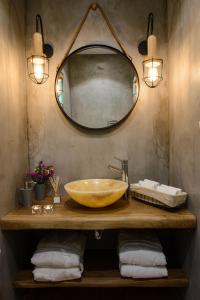 La salle de bains est pourvue d'un lavabo en or et d'un miroir. dans l'établissement Gatzea Villas, à Kato Gatzea