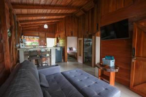 a living room with a couch and a kitchen at Cabaña ITZE in Fortuna