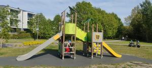 a childrens playground with a slide and play equipment at Rannaäärne modernne korter uues majas in Pärnu