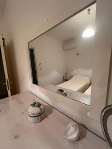 a mirror in a room with a bed and a sink at Résidence LO MONACO Haut de villa, Appartements et Studios in San-Nicolao +116 photos