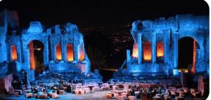 un gruppo di persone che si trovano di fronte a un edificio con luci blu di Southern Comfort Sicily Holidays a Letoianni