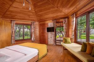 a bedroom with a bed and a couch and windows at Mandarin Bungalow in Alanya