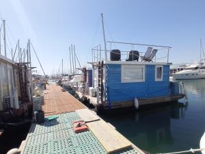 a blue boat docked at a dock in the water at Houseboat BluSeaDream Alghero in Alghero