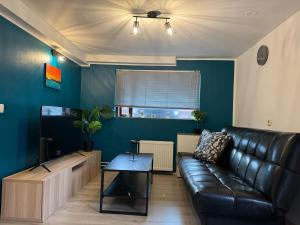 a living room with a leather couch and a table at Aurora cozy Apartments in Ólafsvík