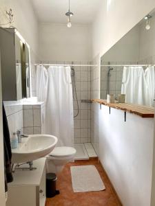 a white bathroom with a sink and a toilet at Das "Alte Jagdhaus" - mit großem Grundstück für 3 Personen in Groß Garz