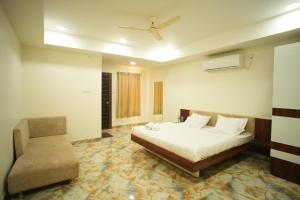 a bedroom with a bed and a chair at Bhandari Palace in Vidisha +10 photos