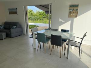 a dining room with a glass table and chairs at Sables des Dunes, jolie maison neuve tout confort, 3 chambres, vacances famille ou entre amis, 500 m plage in Bretignolles-sur-Mer