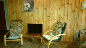 a living room with two chairs and a television at Antucalhue Mountain Resort in Antuco