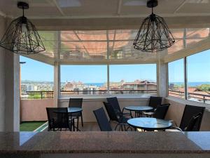 a restaurant with tables and chairs and a large window at Guest rooms Marina in Obzor
