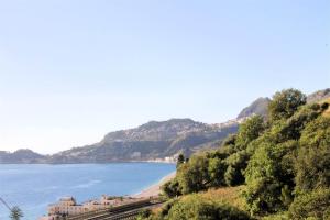 a view of a beach with a building and the ocean at Maremonti in Letojanni