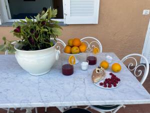 een tafel met fruit erop en een potplant bij Un Paradiso a Sorrento con piscina in Massa Lubrense
