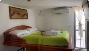 a bedroom with a bed with a green blanket and a window at Sweet home A&C in Conversano
