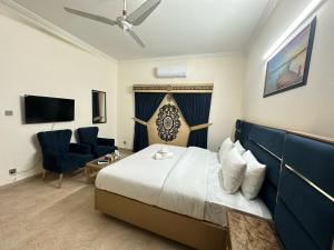 a hotel room with a bed and a chair and a television at Family Cottage Islamabad in Islamabad