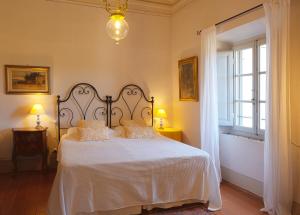 ein Schlafzimmer mit einem Bett mit weißer Bettwäsche und einem Fenster in der Unterkunft Agriturismo Il Ponticello in Vaiano