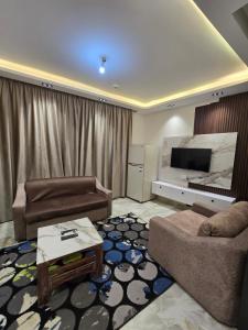 a living room with two couches and a television at porto marina 3 in El Alamein