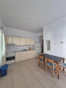 a kitchen with white cabinets and a table in it at Iliaxtida apartments in Philotium