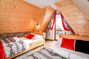 two beds in a room with wooden walls at "Czarna Turnia "Zakopane in Zakopane
