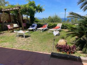 een groep stoelen en een tafel in een tuin bij Un Paradiso a Sorrento con piscina in Massa Lubrense +67 foto's