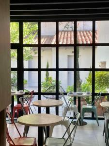 a room with tables and chairs and a large window at Huli B&B in Mendoza