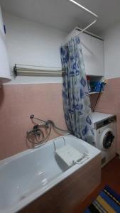 a bathroom with a tub and a washing machine at Matej3 in Niš