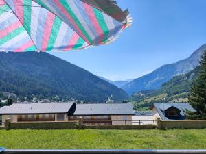 a colorful umbrella in a field with mountains in the background at Pfeiren Leukerbad in Leukerbad