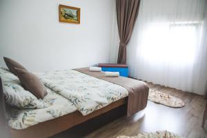 a bedroom with a bed with a window and a rug at House Duzi in Duži