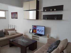 a living room with a couch and a tv at Kyriaki's Studio Aigina in Souvala