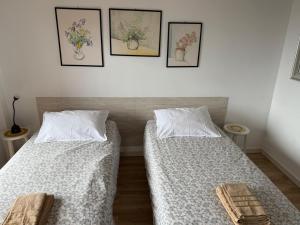 twee bedden in een kamer met foto's aan de muur bij Valle Luz Apartment Ocean View in Puerto de la Cruz +16 foto's