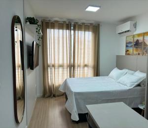 a small bedroom with a bed and a window at Loft Boa Viagem - Uni Studios in Niterói